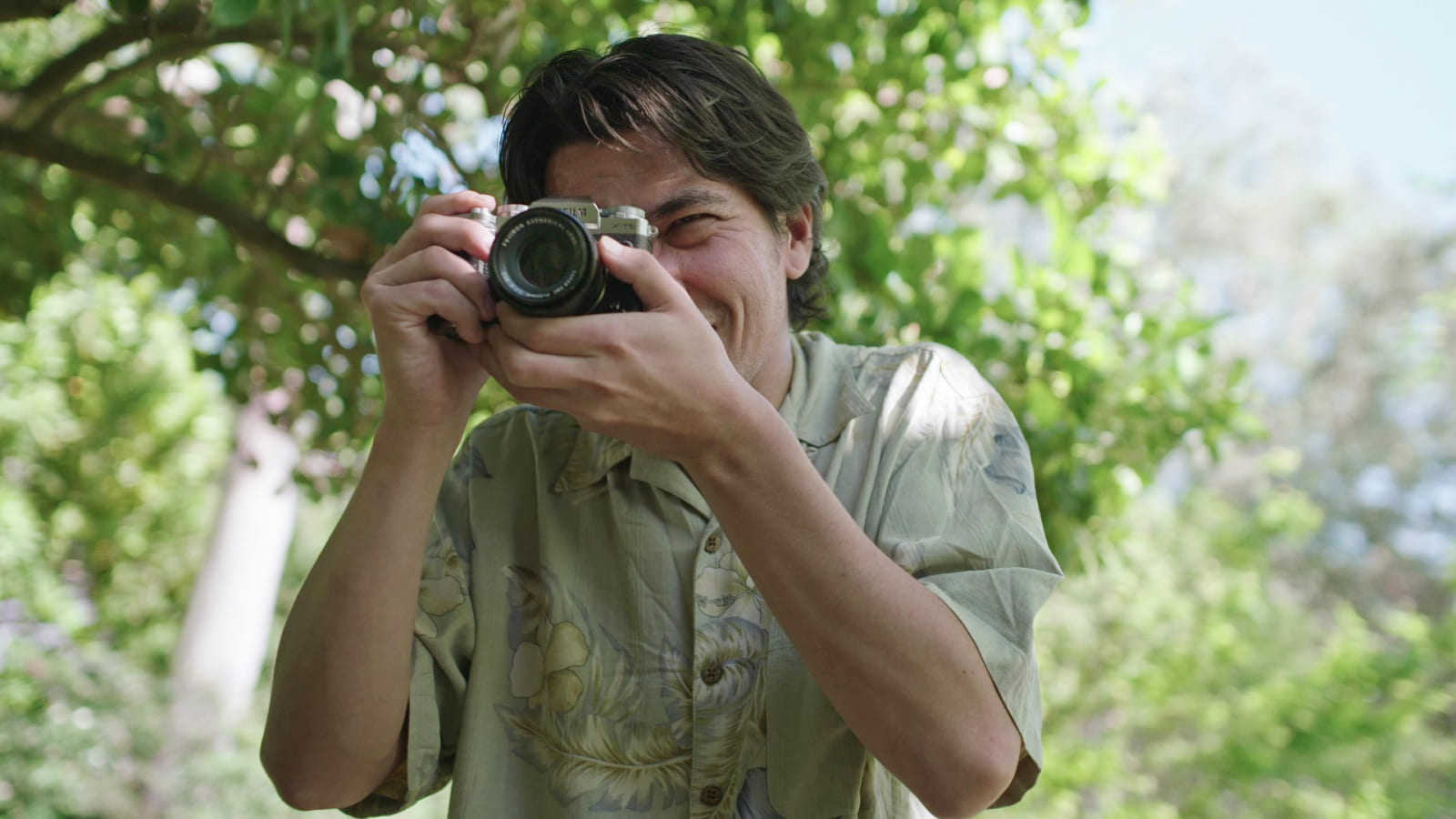 'A man taking a photo with a smile.'
