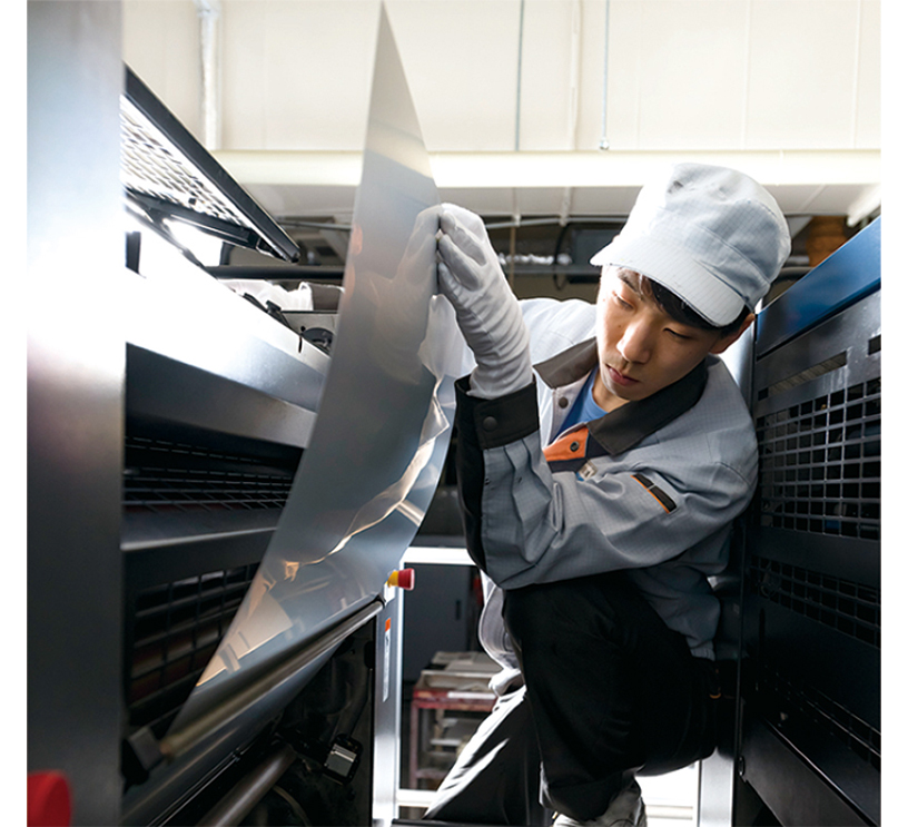 印刷機にCTPプレートを設置する作業員
