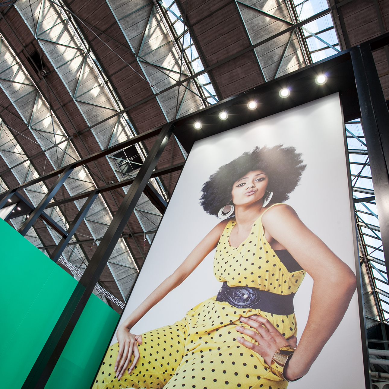 Large poster of a model wearing a yellow polka dot dress