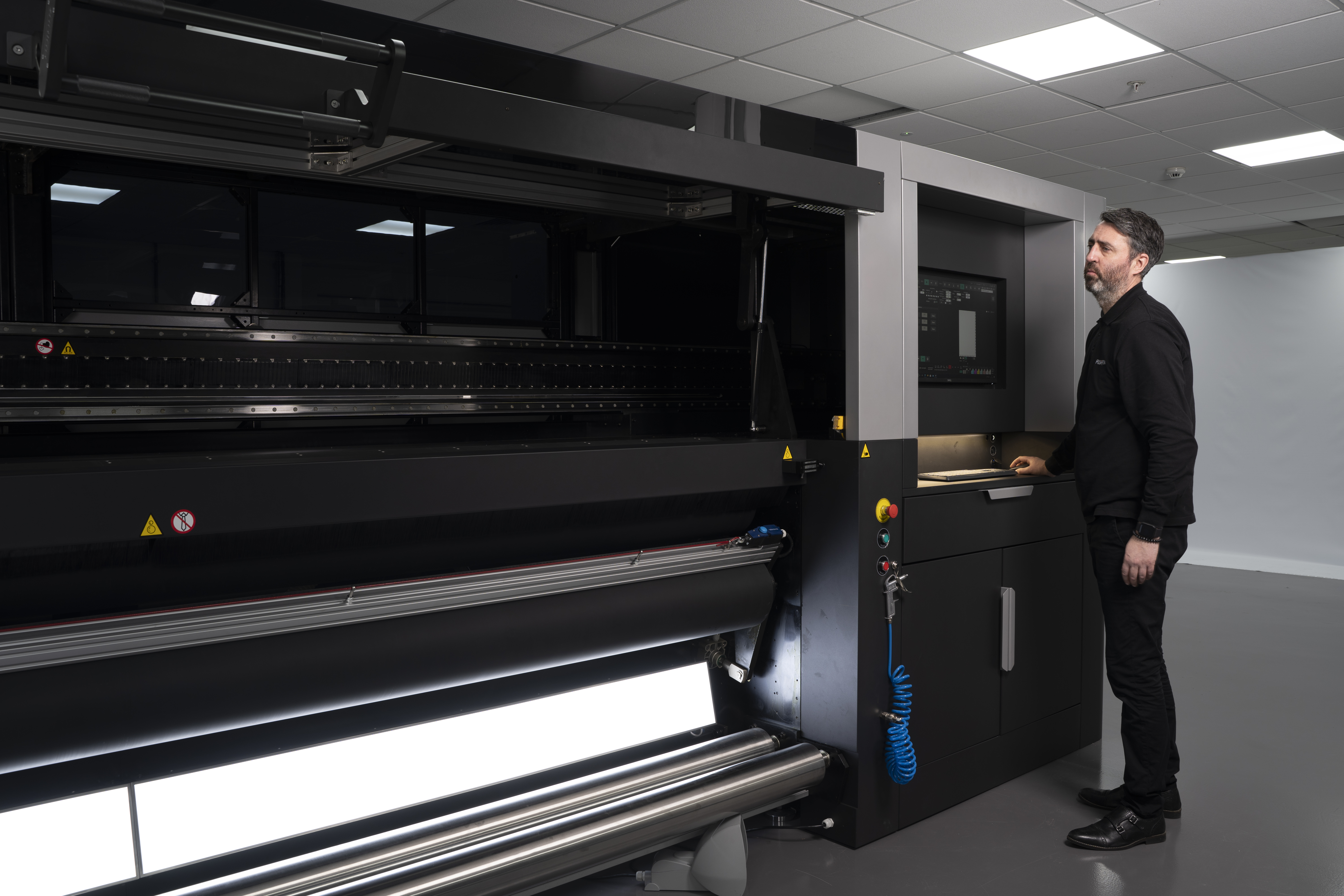 Technician operating a large industrial printer
