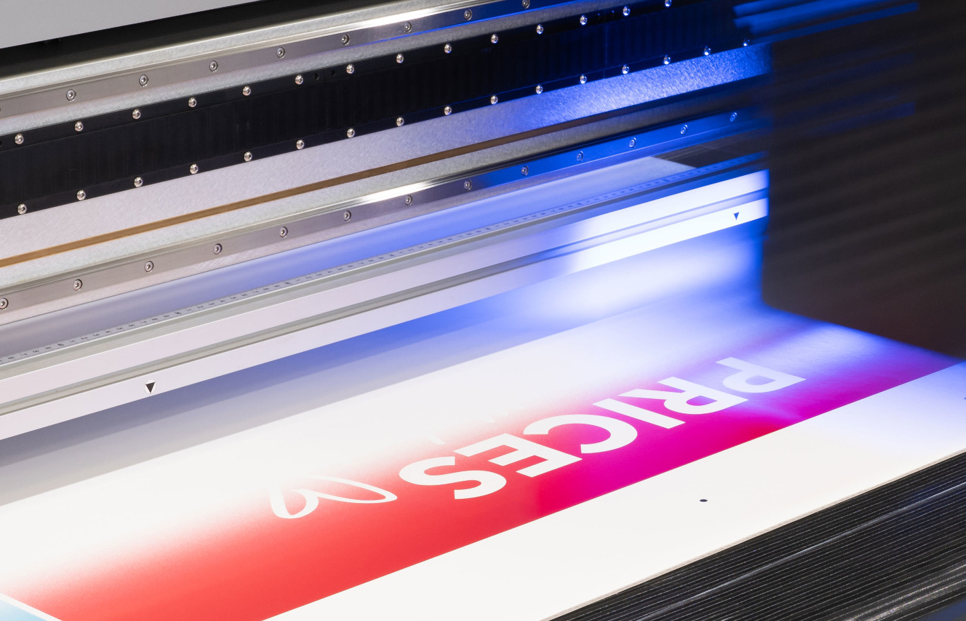Large format printer producing a red and white banner with the word "PRICES" and a heart symbol.