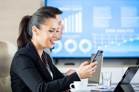 woman looking at phone in conference room
