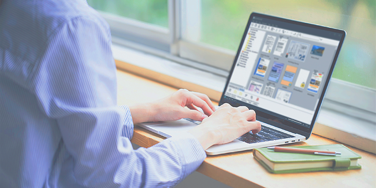 A person working with a laptop at the window side.