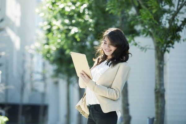 Woman remote working on tablet outdoors on the go