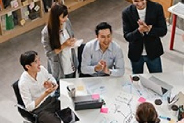 Young professional communicating with coworkers at a virtual meeting.